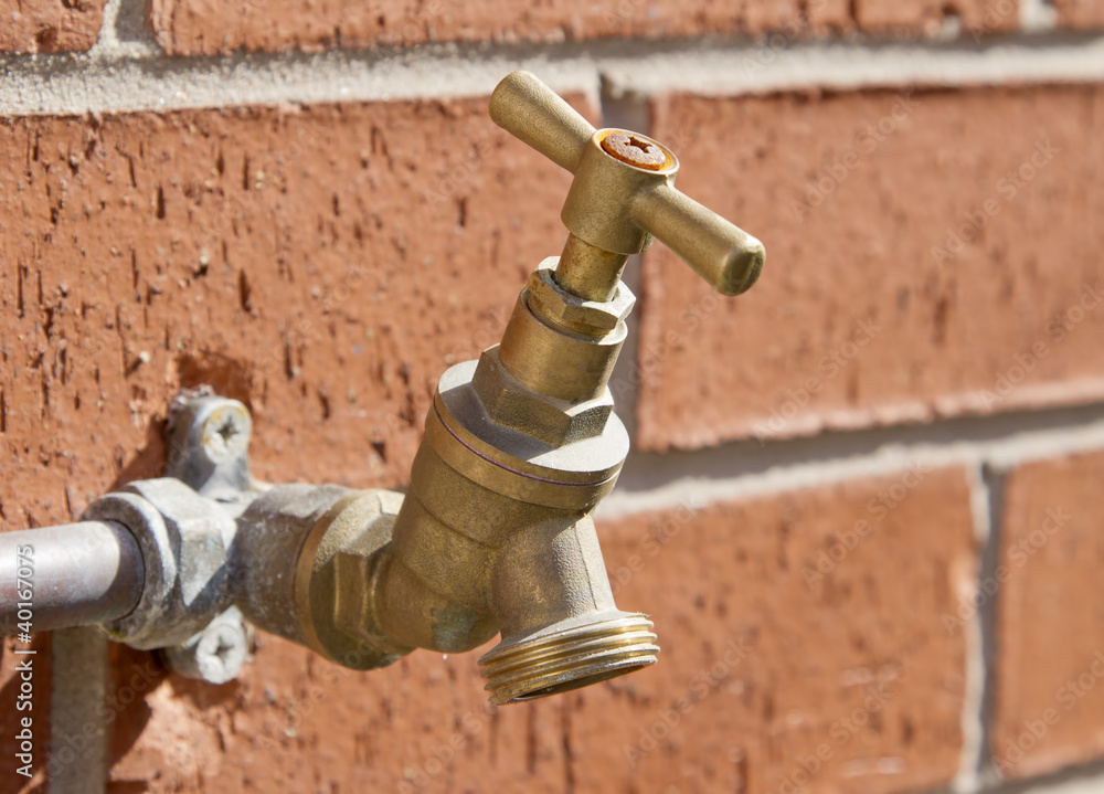 Outside tap on brick wall